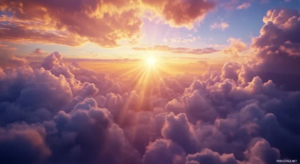 Clouds forming intricate, wispy shapes across the horizon during a peaceful sunrise, with beams of light breaking through the cloud cover.