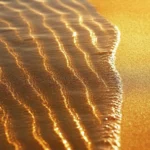 A simple iPhone wallpaper of a smooth beach with soft, flowing waves and a golden horizon.