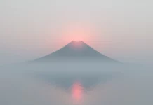 A simple desktop  HD wallpaper features a single mountain peak with a soft, misty atmosphere.