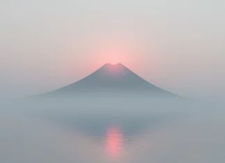 A simple desktop  HD wallpaper features a single mountain peak with a soft, misty atmosphere.