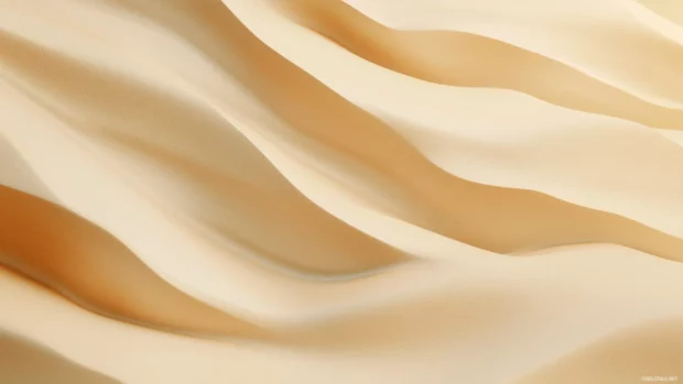 A simple wallpaper of a smooth sand beach with soft, flowing waves and a pale golden sky.