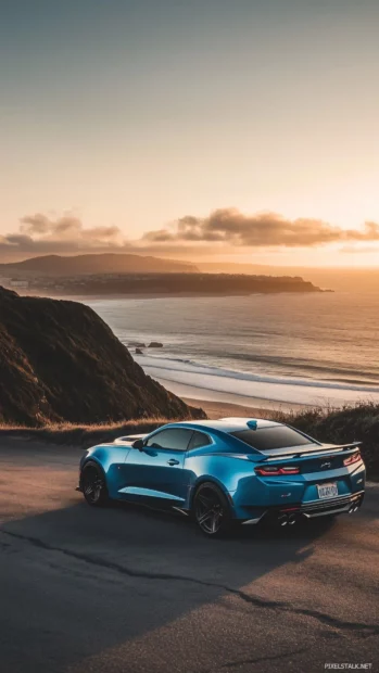 A 202 Camaro ZL1 in deep metallic blue, parked on a coastal road with the ocean in the background.