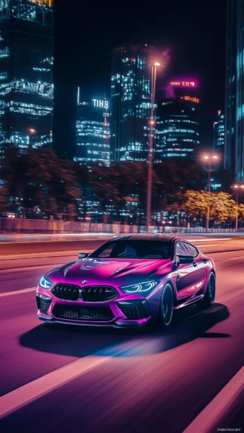 A BMW M8 Gran Coupe cruising down an empty road at night, with neon city lights.