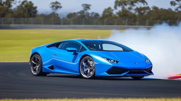 A Lamborghini Huracán in vibrant blue drifting on a racetrack with smoke trails.