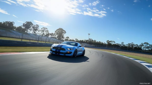 A Mustang Shelby GT500 racing on a closed racetrack, with motion blur showcasing the car’s power and agility as it zooms around the curve under a bright blue sky.