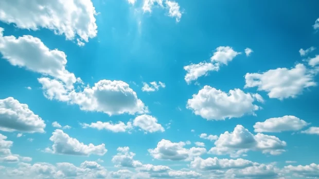 A blue sky with soft fluffy clouds drifting slowly across the horizon, creating a peaceful and airy atmosphere.