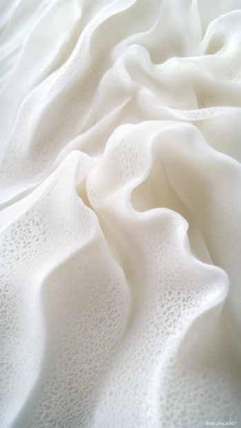 A close up aesthetic shot of waves gently washing over smooth white sand, foamy water.