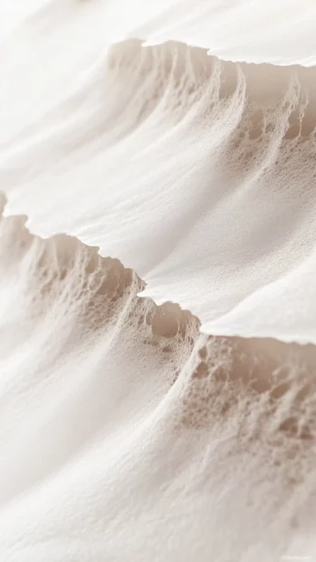 A close up aesthetic shot of waves gently washing over smooth white sand, foamy water creating a natural gradient, a soft and minimalist tropical beach design.