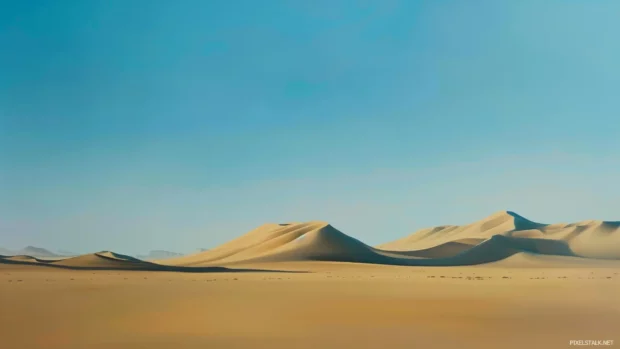 A cool bronze desert landscape with dunes and a clear blue sky.