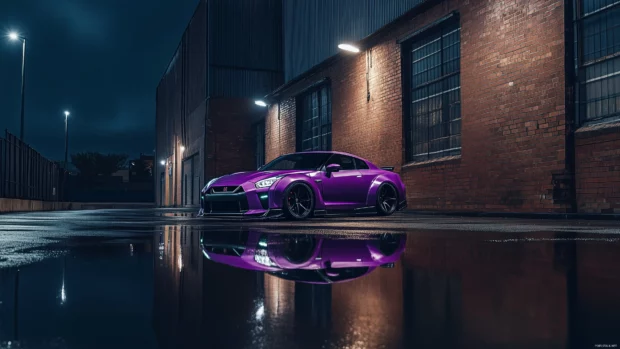 A custom purple Nissan Skyline, modified with wide body kits and matte black wheels, sitting in front of an industrial warehouse at night with street lights shining.