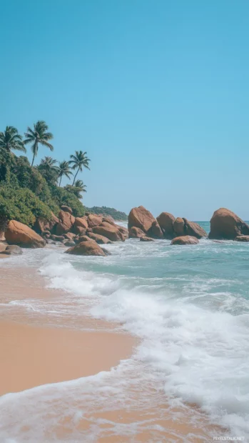 A picturesque beach with turquoise waves washing up on a soft sandy shore.