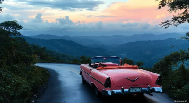 A pink vintage car parked on a scenic mountain road.