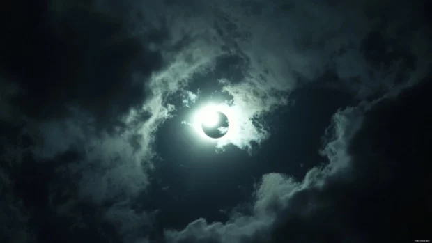 A sky with a solar eclipse partially obscuring the sun.