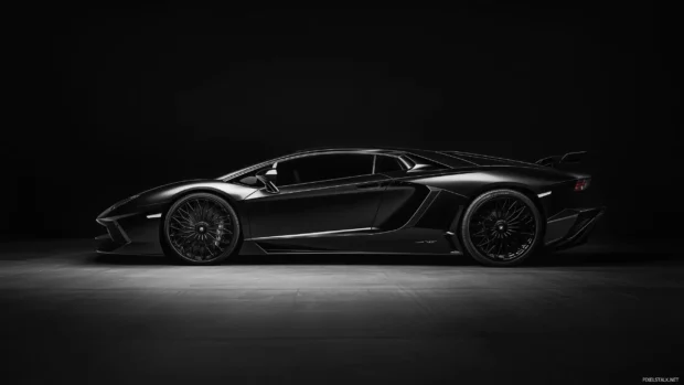 A sleek black Lamborghini Aventador illuminated by soft spotlights, with subtle reflections enhancing its sharp angles and a pure black background.