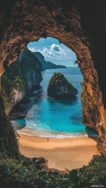 A tropical beach with a natural rock arch framing the ocean view, lush green foliage on the rocks, calm blue water.