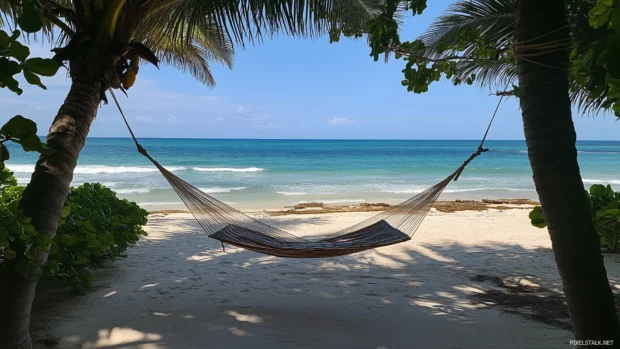 A tropical paradise view from a hammock tied between two palm trees, overlooking a calm beach, soft white sand, and endless turquoise ocean waves.