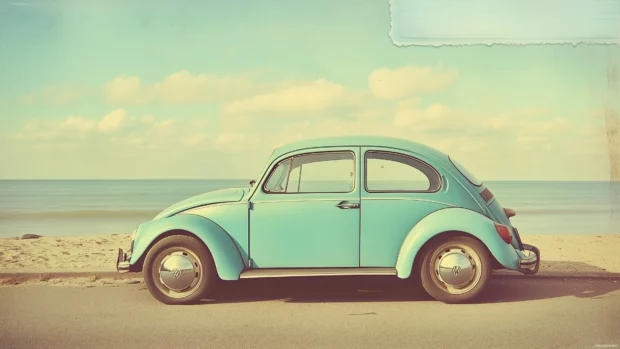 A vintage Volkswagen Beetle parked at a beach.