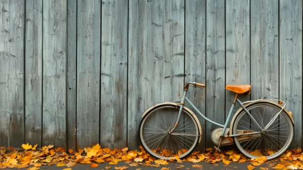 Cool Vintage Wallpaper HD with a lone vintage bicycle leaning against an old wooden fence with autumn leaves scattered on the ground.