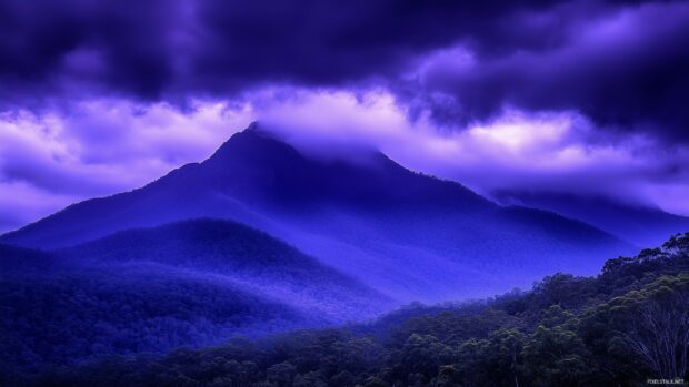 Dark purple storm clouds rolling in over a mountain range.