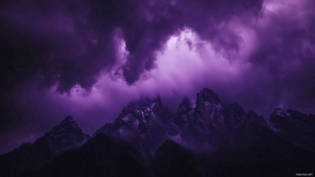 Dark purple storm clouds rolling in over a mountain range, casting dramatic shadows.