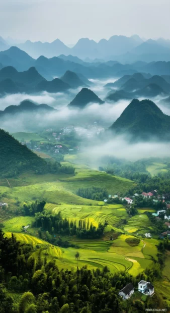 Rain 4K wallpaper HD with rainstorm over a scenic mountain valley, foggy clouds hovering between mountain peaks, rain soaked landscape with lush greenery.