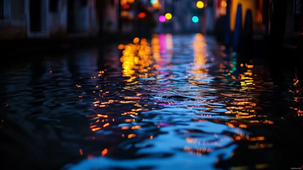 Rain falling on a calm city canal at dusk, water reflecting colorful lights from nearby buildings and streetlamps, ripples gently spreading across the surface.