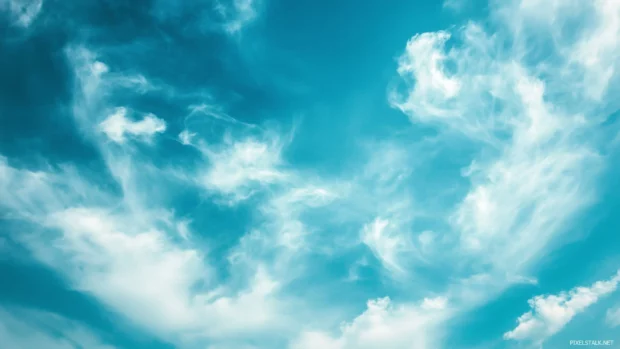 Wispy cirrus clouds stretching across a deep blue sky, evoking a sense of freedom and endless space.