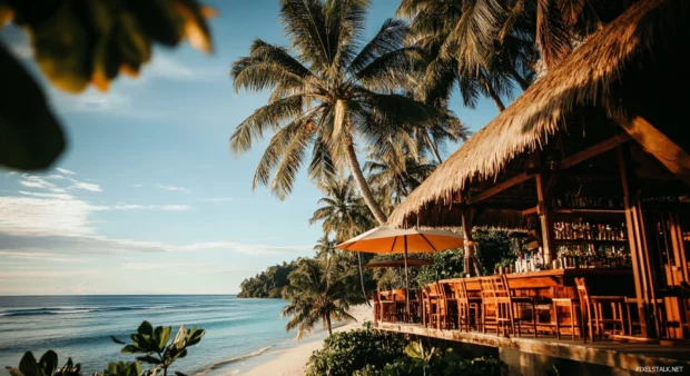 A HD beachside bar with a thatched roof, nestled among palm trees wallpaper.