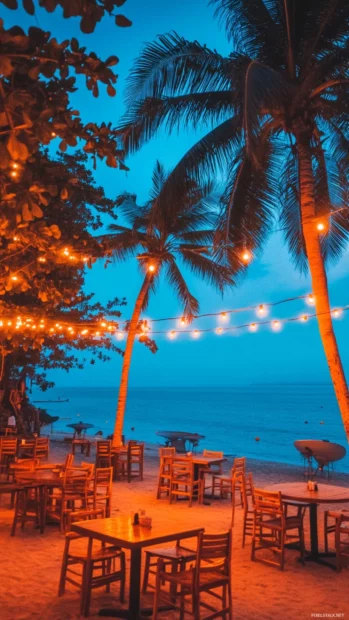 A beachside caffe with string lights and palm trees for iPhone wallpaper.