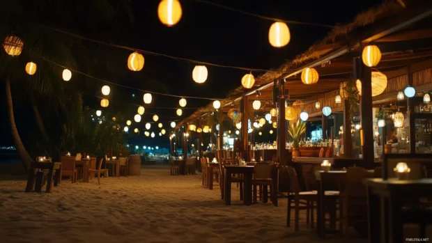 A beachside restaurant with lanterns and string lights in the dark night.