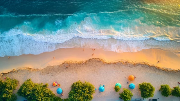 A bird eye view of a beach at sunrise with colorful umbrellas.