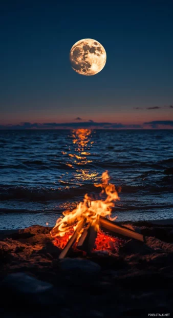 A full moon shining brightly over a dark blue ocean wallpaper.