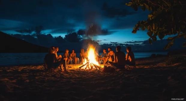 A group of friends gathering around a bonfire on a beach at night.