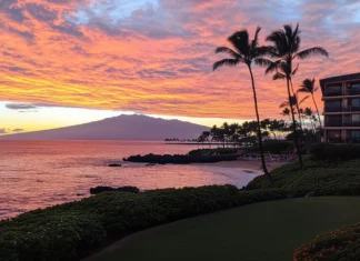 A picturesque sunset at a Hawaii beach with vibrant orange and pink skies reflecting on the ocean .