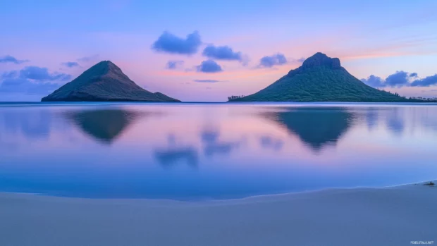 A picturesque sunset at a Hawaii beach with vibrant orange and pink sky.