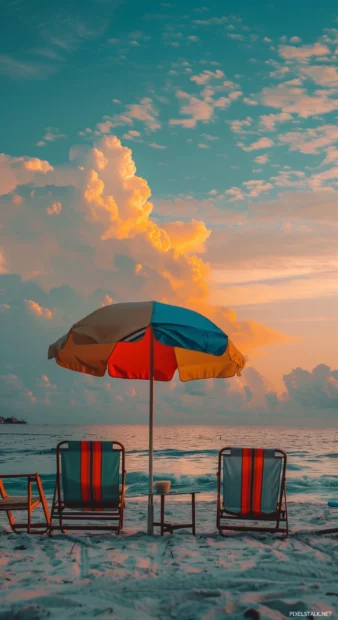 A preppy beachy scene at sunset with colorful umbrellas.