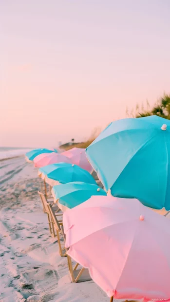 A preppy vibe beach scene at sunset with colorful beach umbrellas.