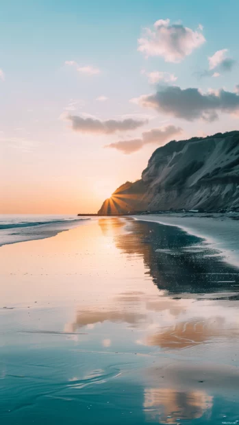 An aesthetic beach at sunrise with pastel colors reflecting on calm waters.