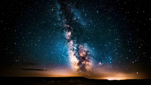 A breathtaking Milky Way galaxy desktop background from a dark desert landscape, stars shining brightly.