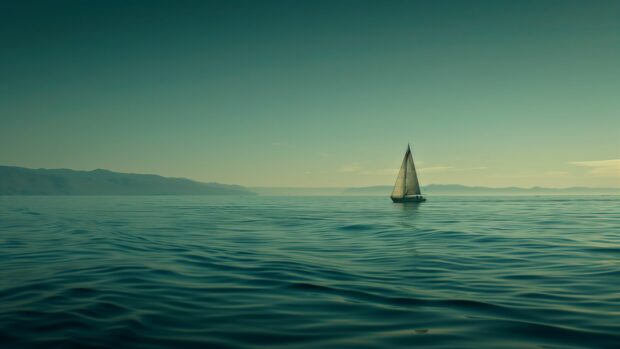 A quiet ocean wallpaper 4K with a lone sailboat in the distance.