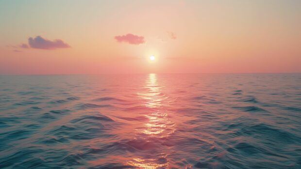 A serene ocean desktop HD wallpaper with a beautiful sunrise, soft pink and orange hues.