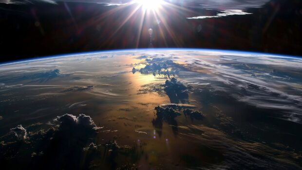 A stunning scene of Earth from space desktop background with the sunrise casting a golden glow on the horizon, highlighting the curvature of the planet.