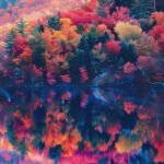 Aesthetic Nature iPhone Wallpaper with Serene lake surrounded by vibrant autumn foliage, mirror like reflections, and soft morning light.