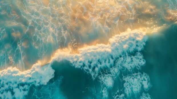 An aerial view of a vast ocean hd wallpaper with gentle waves and sunlight glinting off the surface.