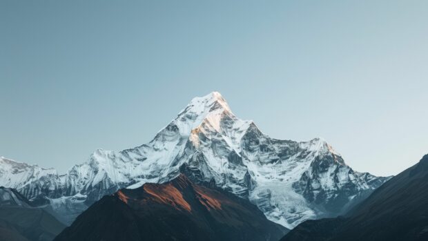 Free Download Wallpaper 4K with a snowy mountain peak with a clear, crisp winter sky.