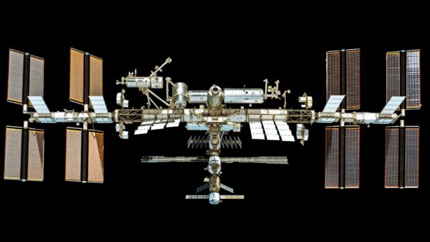 Free a panoramic view of the International Space Station with all its modules and solar arrays fully extended, floating in orbit HD wallpaper.