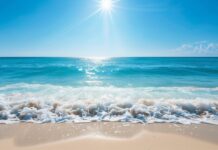 HD Desktop Wallpaper with a bright sunny day over a clear blue ocean with gentle waves.