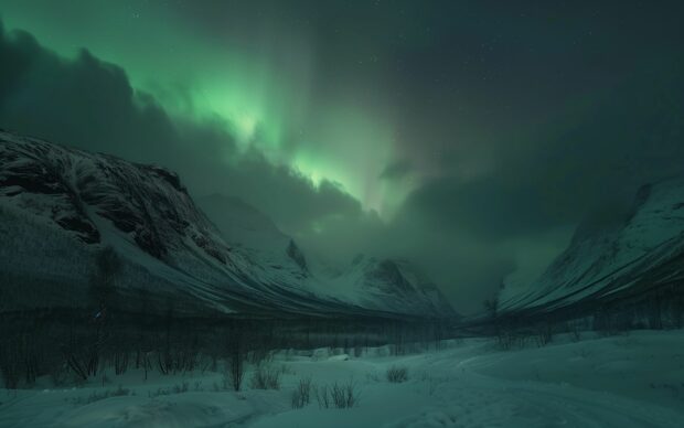 HD Wallpaper Northern Lights illuminating a snowy mountain range.