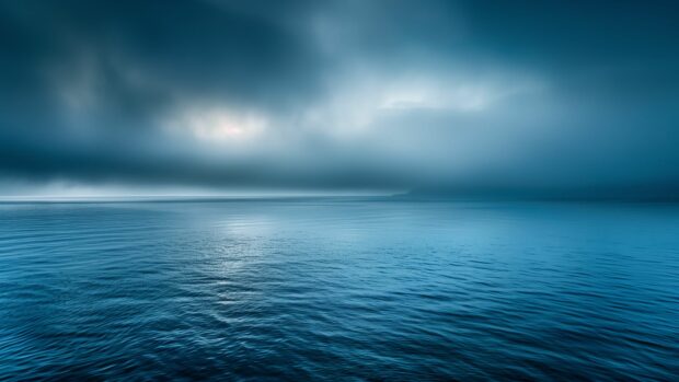 Ocean desktop wallpaper 4K with a misty morning over a calm ocean with light fog.