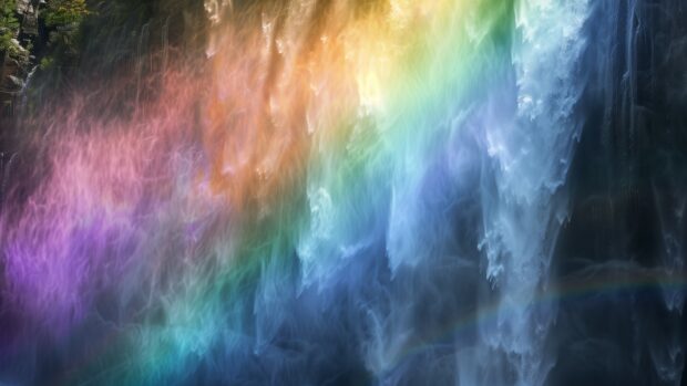 4K HD Wallpaper with a rainbow over a waterfall, with mist and sunlight creating a magical atmosphere.